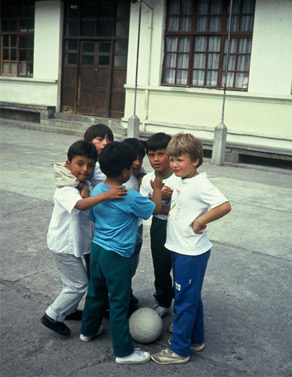 Ett gäng med fotbollsspelande pojkar står i en ring och pratar.